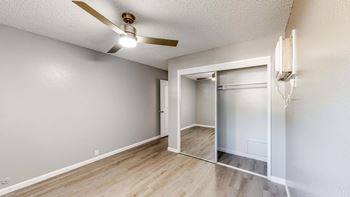 A room with a ceiling fan and a doorway leading to another room